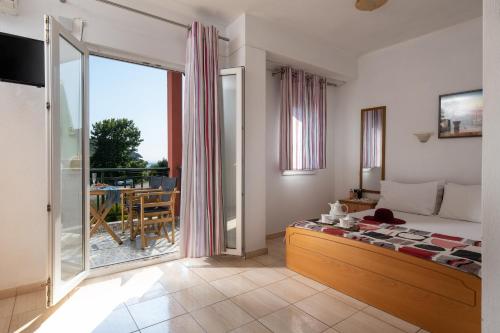 a bedroom with a bed and a sliding glass door at Studios Kofos Limin in Porto Koufo