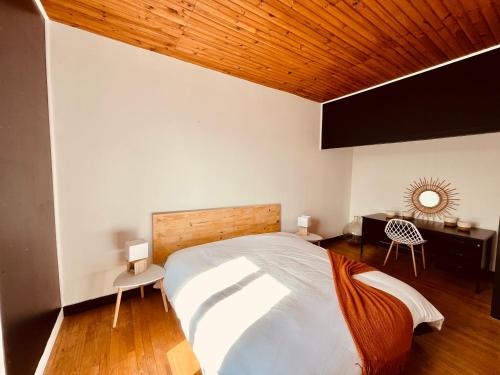 - une chambre avec un grand lit et un plafond en bois dans l'établissement Au Bonheur Arédien, à Saint-Yrieix-la-Perche