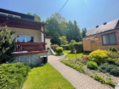 a house with a walkway in front of a yard at Penzion U Rodinky in Bělá pod Pradědem