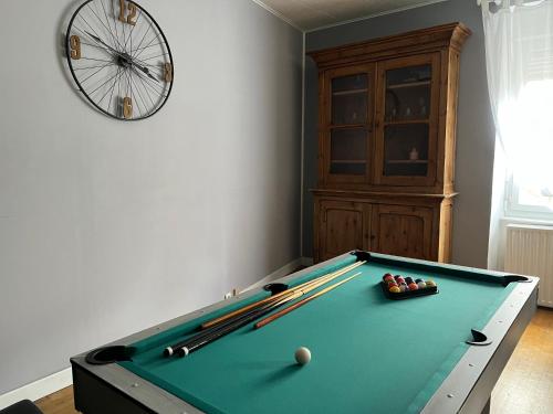 - un billard dans une salle avec une horloge dans l'établissement Au Bonheur Arédien, à Saint-Yrieix-la-Perche
