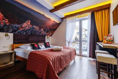 a bedroom with a bed with a painting on the wall at SUMMIT-Szczawnica-Centrum in Szczawnica