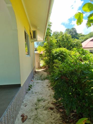 a house with a walkway next to a building at Le Nid de Bea Self-catering Apartments in La Digue