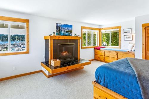um quarto com uma cama e uma lareira em Pintails Lodge em Port Ludlow