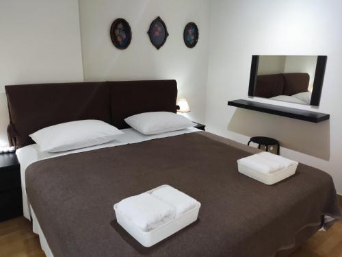 una camera da letto con un grande letto con due cuscini bianchi di A&J Apartments or Rooms athens airport a Markopoulo