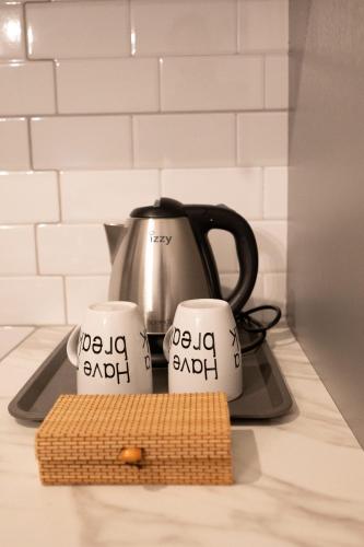 a coffee pot and two mugs on a stove at Casa en el Lago -Luxury apartments in the historical center of Ioannina in Ioannina