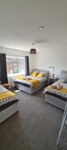 a room with three beds and a window at Well presented 3 Bed House- 9 Guests - Great for Leisure stays or Contractors -NG8 postcode in Nottingham
