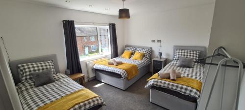 um quarto com 2 camas individuais e uma janela em Well presented 3 Bed House- 9 Guests - Great for Leisure stays or Contractors -NG8 postcode em Nottingham
