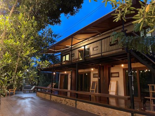 een huis met een terras en een balkon bij Banmai87 Guest House บ้านไม้87 เกสต์เฮ้าส์ in Phra Nakhon Si Ayutthaya