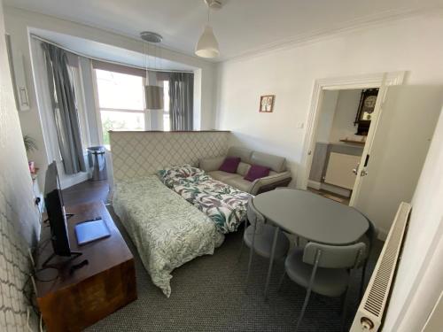 Schlafzimmer mit einem Bett, einem Tisch und einem Schreibtisch in der Unterkunft The Walnut Suite lovely one bedroom flat in Stoke. in Plymouth