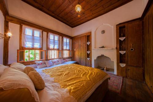 ein Schlafzimmer mit einem großen Bett in einem Zimmer mit Fenstern in der Unterkunft Meymune Valide Konağı in Safranbolu
