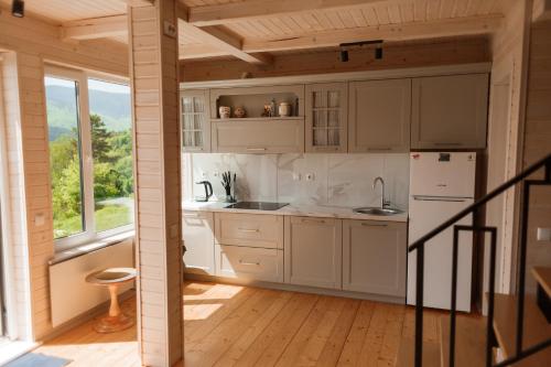 a kitchen with white appliances and a wooden floor at Top House in Yaremche