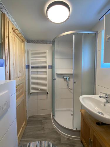 uma casa de banho com um chuveiro e um lavatório. em Küstenkind - 3 Schlafzimmer - 5 Personen em Lobbe