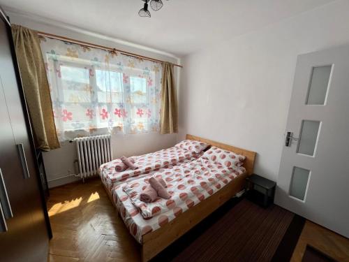 a bedroom with a bed with pink sheets and a window at Rose City Apartment in Oradea