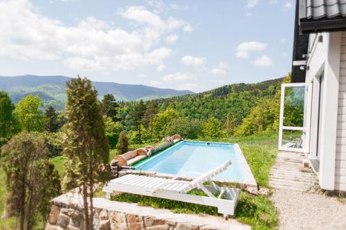 an outdoor swimming pool in a yard next to a house at Top House in Yaremche