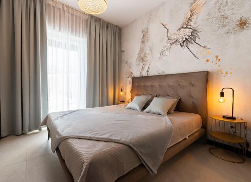 um quarto com uma cama com uma pintura de pássaro na parede em Apartament Premium 28 Laguna Beskidów nad Jeziorem Żywieckim - Dream Apart em Zarzecze