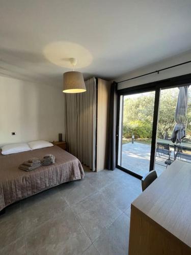 een slaapkamer met een bed en een groot raam bij Studio indépendant avec accès piscine in Uzès