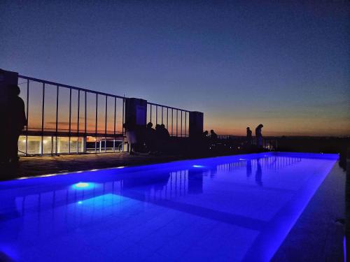 a swimming pool with blue lights in front of a building at Lux Suites Coral Bells Studio Apartments in Kiambu