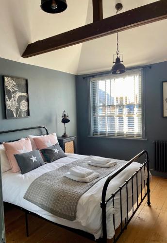 a bedroom with a large bed with blue walls at Fabulous apartment seconds from beach by Whitstable-Holidays, Pudding Pan in Whitstable