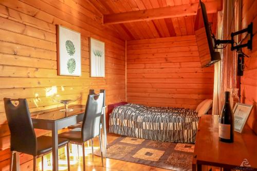 a room with a bed and a table and chairs at Vila da Laje - Onde a Natureza o envolve - Serra da Estrela in Oliveira do Hospital