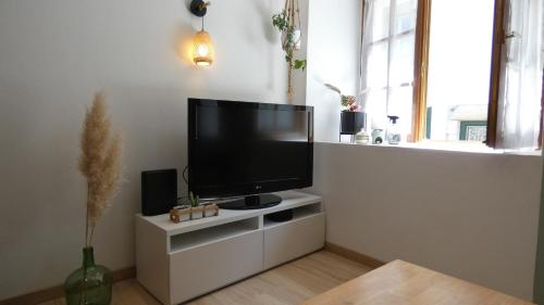 a living room with a flat screen tv on a white cabinet at Maison Centre ville " 100 marches" in Morlaix