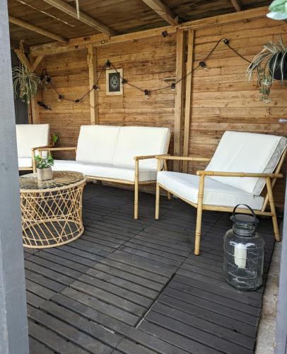 a patio with two white chairs and a table at Ferienhaus Lausitz in Lauta