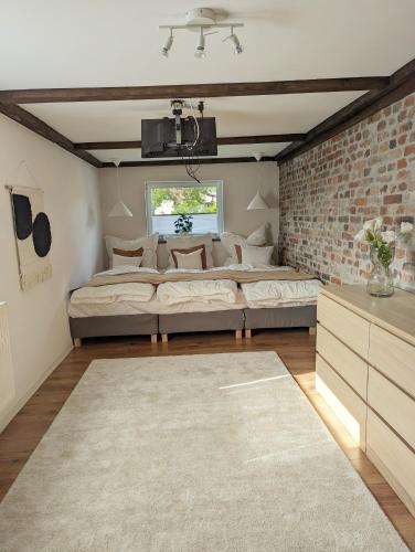 a living room with two beds and a brick wall at Ferienhaus Lausitz in Lauta