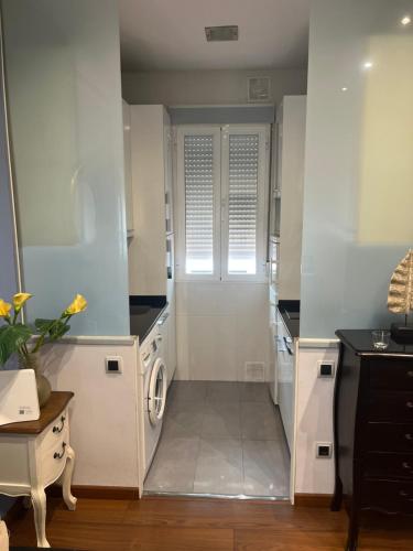 a kitchen with white cabinets and a washer and dryer at Lavapiés Classy in Madrid