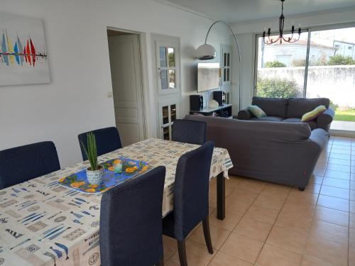 un salon avec une table et un canapé dans l'établissement Vacances en famille a Oleron, au Château-dʼOléron