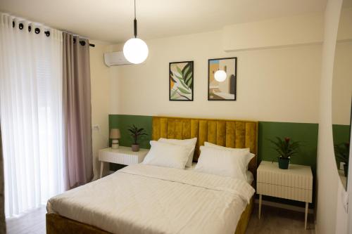 - une chambre avec un grand lit et 2 tables dans l'établissement Three doors apartments, Kiwi 1+1 apartment, à Tirana