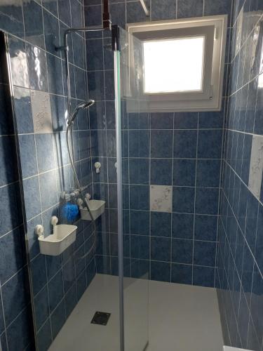 une salle de bain avec une douche en verre avec une fenêtre dans l'établissement Vacances en famille a Oleron, au Château-dʼOléron