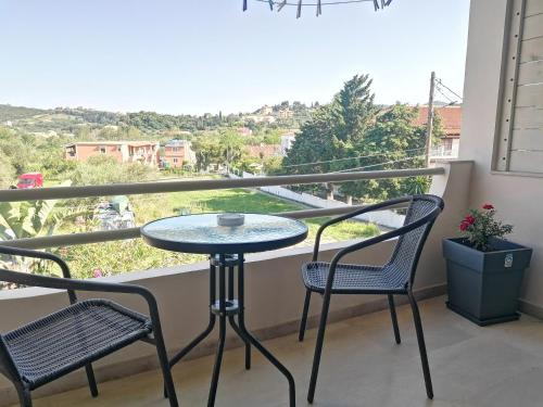 a table and two chairs on a balcony with a view at Makis Apartments in Arillas