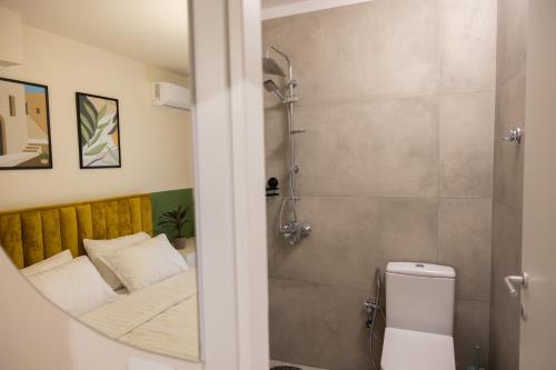 un piccolo bagno con letto e doccia di Three doors apartments, Kiwi 1+1 apartment a Tirana