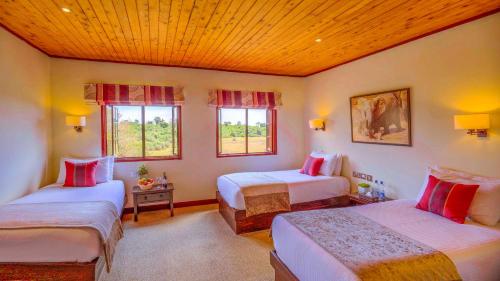 1 dormitorio con 2 camas y 2 ventanas en The Ark Lodge, en Nyeri