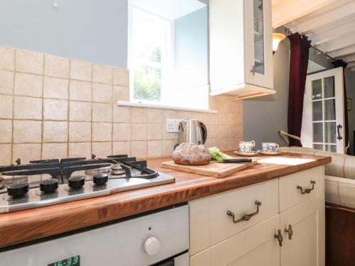 a kitchen with a stove and a counter top at Clover Cottage - Delightful 1-bed cottage in the heart of Ambleside in Ambleside