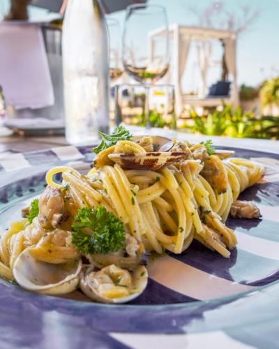 a plate of pasta with shrimp and mushrooms on a table at Approdo Resort Thalasso Spa in Castellabate