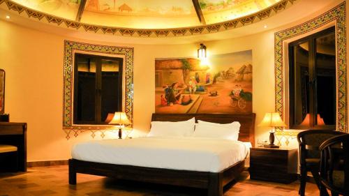 1 dormitorio con 1 cama y una pintura en la pared en Seven Sky Clarks Exotica, en Bhuj