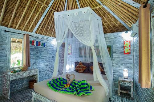 a bedroom with a bed with a canopy at Naturale Villas in Nusa Lembongan