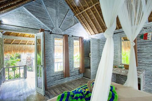 a room with a bed and some windows at Naturale Villas in Nusa Lembongan