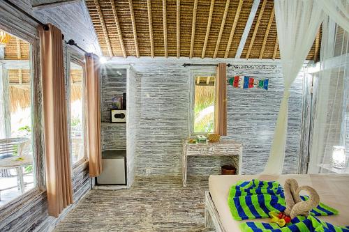 a bedroom with a bed in a room with windows at Naturale Villas in Nusa Lembongan