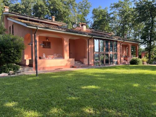 une maison avec une pelouse verte devant elle dans l'établissement Guest House La Selvotta, à Formello