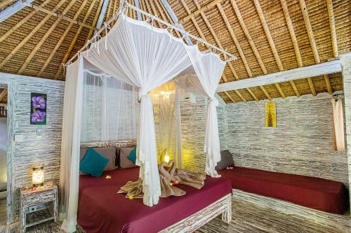 a bed with a canopy in a room at Naturale Villas in Nusa Lembongan