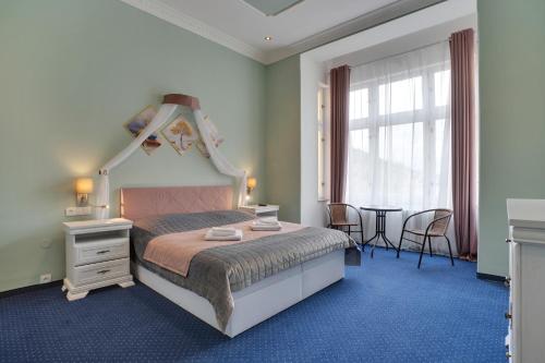 a bedroom with a large bed and a table at Aphrodite Hotel Marianske Lazne in Mariánské Lázně