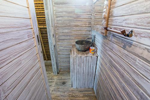 a small bathroom with a bucket on a table at Naturale Villas in Nusa Lembongan