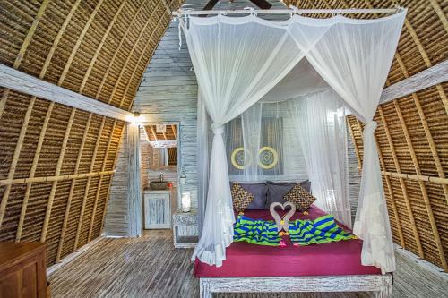 a bedroom with a bed with a mosquito net at Naturale Villas in Nusa Lembongan