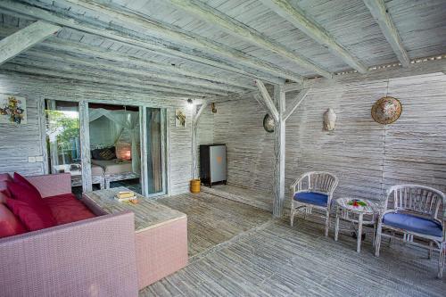 a living room with a couch and chairs and a television at Naturale Villas in Nusa Lembongan