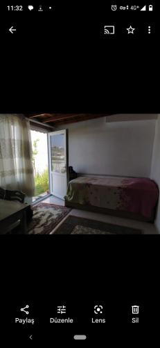 Cartel de un dormitorio con cama y ventana en Avşa kiralık yazlık ev en Marmara