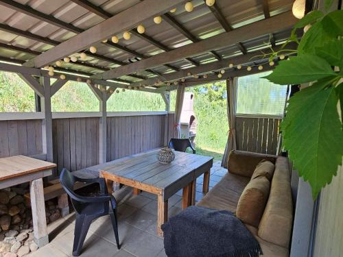 patio z kanapą, stołem i pergolą w obiekcie Vitalny Domek z ogrodem nad jeziorem, 10 min od Mrągowa w mieście Ruska Wieś