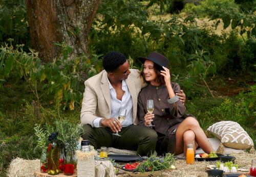 a man and a woman sitting on a picnic blanket at Fairmont Mount Kenya Safari Club in Nanyuki