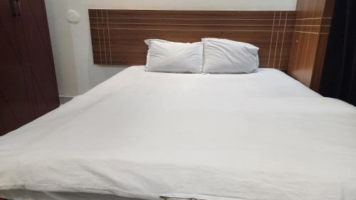 a large white bed with two pillows on it at Dream Palace Resort in Cox's Bazar