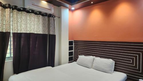 a bedroom with a bed with a black and orange wall at Dream Palace Resort in Cox's Bazar